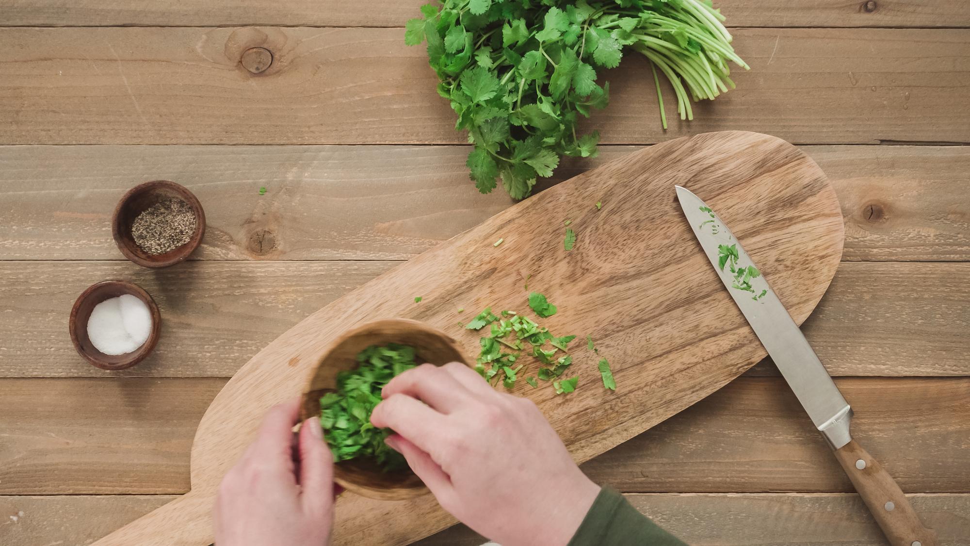 Hands chopping herbs